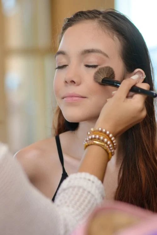 Beauty professional applying makeup to a client