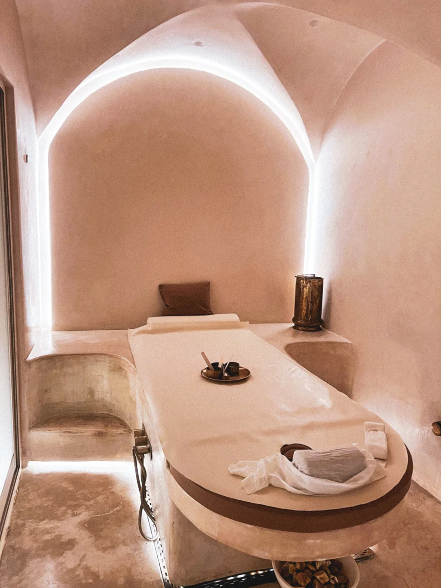 Warm spa treatment room with an illuminated arch and massage bed